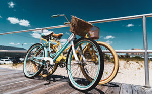 Two bikes leaning on rail