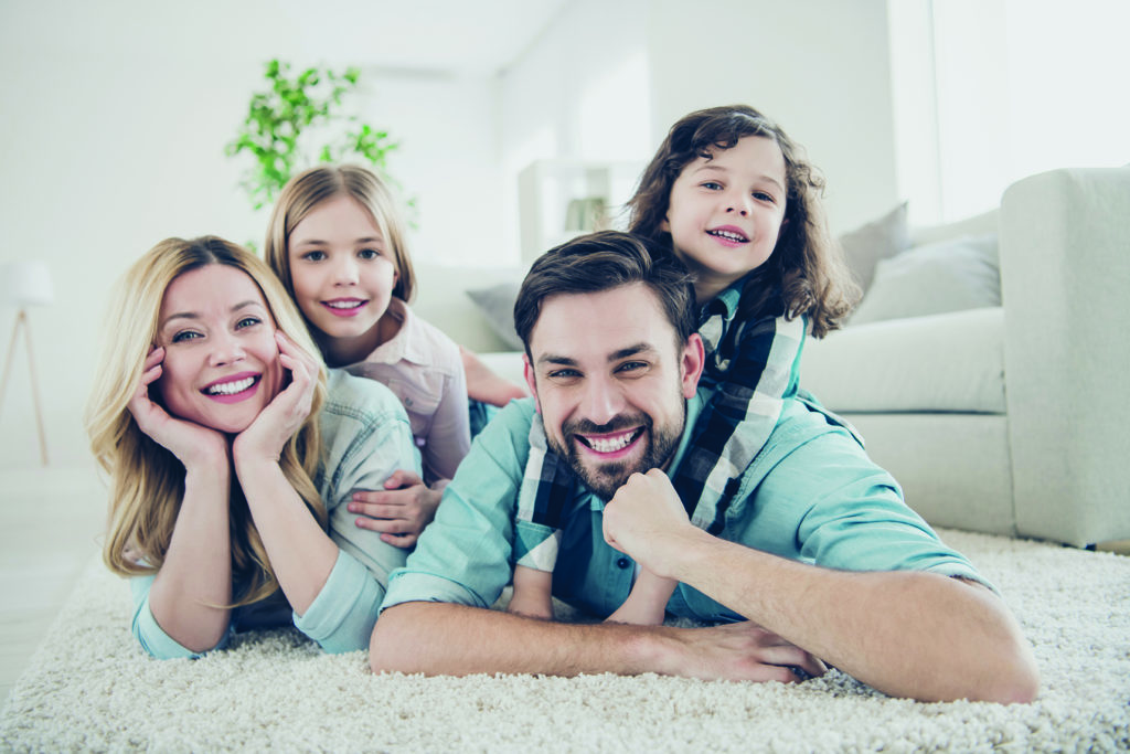 Photo of four members adopted, family lying floor toothy smiling fluffy carpet cozy apartments