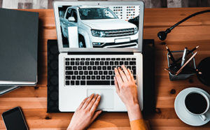 Person viewing a car on a laptop