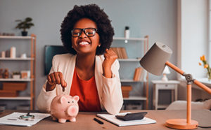 Excited lady making deposit into piggy bank